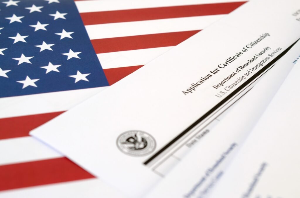 N-600 Application for Certificate of Citizenship blank form lies on United States flag with envelope